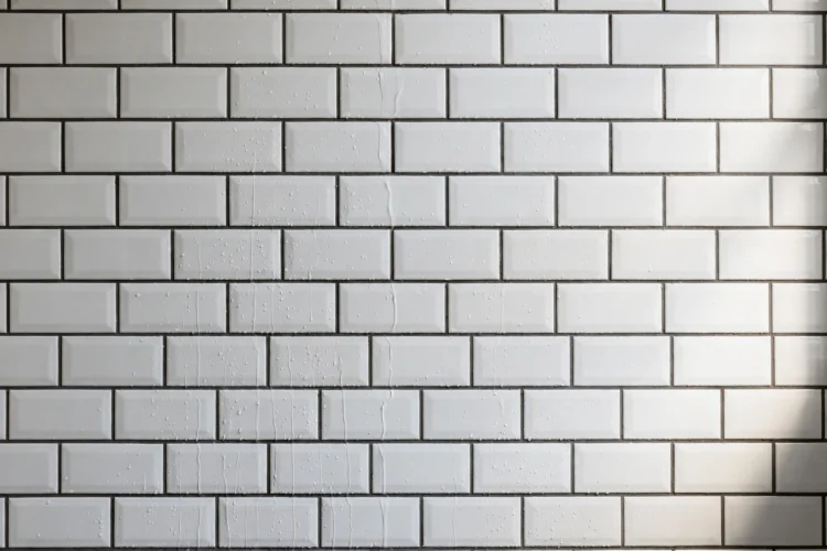 White subway shower tile with contrasting dark gray grout